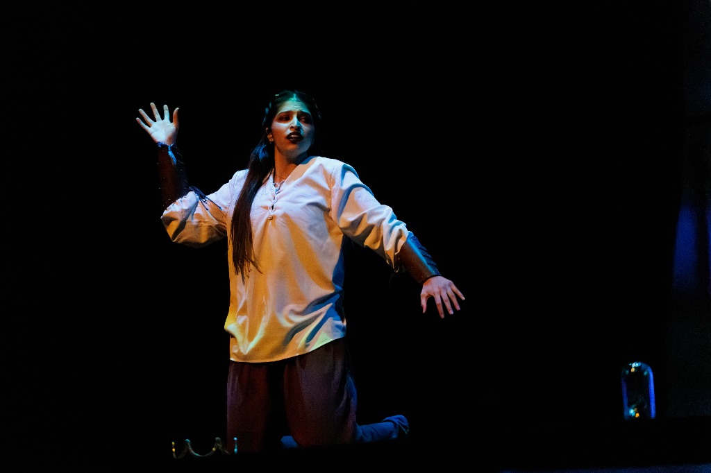TAMU Akh Mastani dancer kneeling and posing dramatically on stage