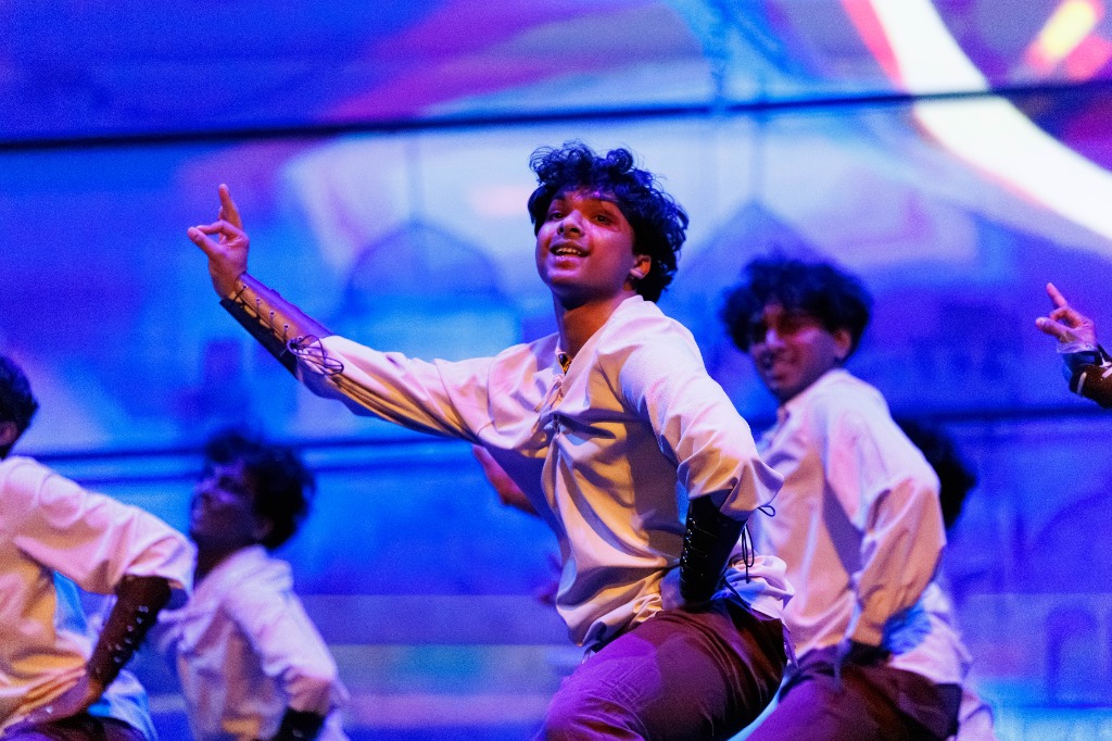 TAMU Akh Mastani dancer performing in the center with arms extended